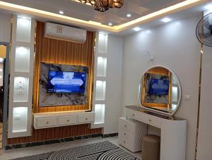 a room with a tv and a mirror at Nour House in Luxor