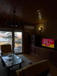 a living room with a coffee table and a window at Mavrovo Lake Chalet in Mavrovo