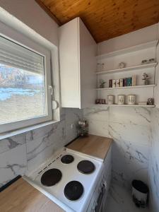 a small kitchen with a stove and a window at Mavrovo Lake Chalet in Mavrovo
