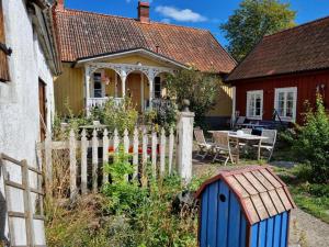 a house with a fence in front of a yard at Elsasgården - Rum för lugn in Mörbylånga