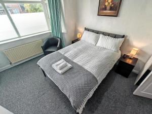 a bedroom with a bed and a chair and a window at Lilac Studio - Self Contained One-Bed Studio Flat in Oxford