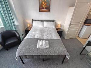 a bedroom with a bed with two towels on it at Lilac Studio - Self Contained One-Bed Studio Flat in Oxford +7 photos