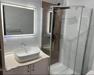 a bathroom with a glass shower and a sink at Waiyavi Apartments in Lautoka