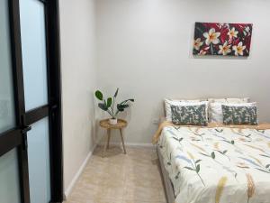 a bedroom with a bed and a table with a plant at Waiyavi Apartments in Lautoka