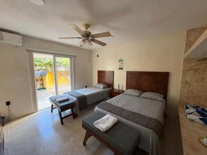a bedroom with two beds and a ceiling fan at Casa Bugambilia Progreso #1 in Progreso