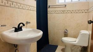 a bathroom with a sink and a toilet at Casa Bugambilia Progreso #1 in Progreso