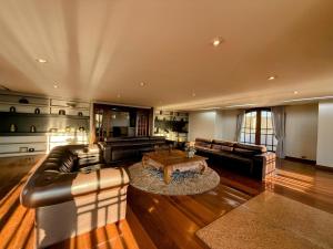 a large living room with leather couches and a coffee table at Luxo no Castelo - Duplex Premium com Lazer total e Piscina aquecida in Campos do Jordão