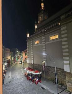 a building with tables and umbrellas on a street at Apto RUA DO LAZER in Santa Teresa +3 photos