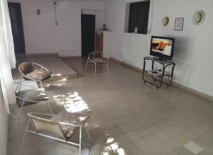 a room with chairs and a television on a tiled floor at Casona Estación Cabra Corral in Coronel Moldes