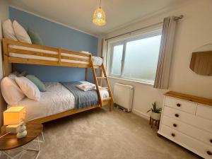 a bedroom with a bunk bed and a window at Cornish coastal escape in Bude in Bude