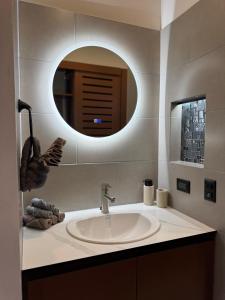 a bathroom with a sink and a round mirror at El Jardín de Martín in Puerto Jiménez +19 photos