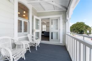 a white porch with white wicker chairs on it at Altitude Studio in Martinborough
