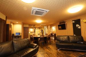 uma sala de estar com um sofá e uma mesa em Guest House Ouka em Takayama