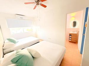 a room with two beds and a ceiling fan at Estrella Azul Penthouse in Cancún