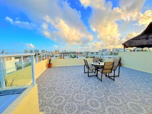 a patio with a table and chairs on a balcony at Estrella Azul Penthouse in Cancún