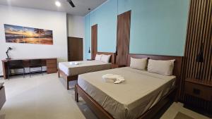 a hotel room with two beds and a desk at El Jardín de Martín in Puerto Jiménez