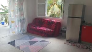 a red chair in a room with a window at Appartement Ti Coquelicot in Rivière-Salée +6 photos
