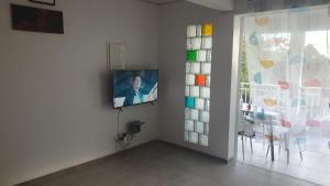 a television on a wall next to a room with a window at Appartement Ti Coquelicot in Rivière-Salée