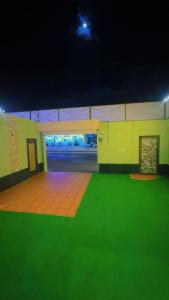 a large room with a green floor and a room with a unintention at شاليهات واحة لافندر in Taif
