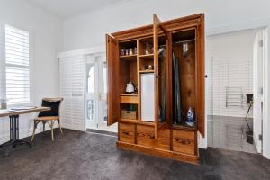 a kitchen with a wooden cabinet with a refrigerator at Altitude Studio in Martinborough