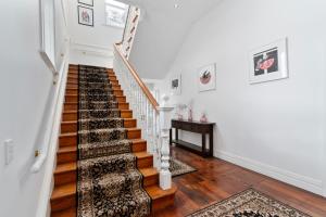 a staircase in a home with white walls and wooden floors at Altitude Studio in Martinborough +18 photos
