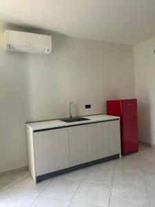 a kitchen with a sink and a red refrigerator at Nuvole e Miracoli - foresteria in Bagnolo Mella +11 photos