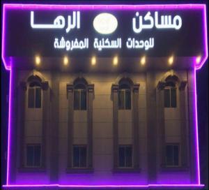 a lit up sign in front of a building at Raha Suites in Dammam