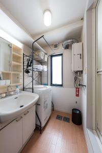 a bathroom with a sink and a washing machine at アルカディアｋ in Aomori