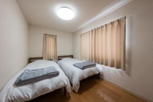 a bedroom with two beds with towels on them at アルカディアｋ in Aomori