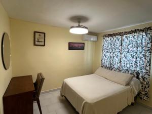 a small bedroom with a bed and a window at Casa Canaan in Monterrey