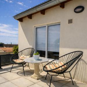 two chairs and a table on a patio at Gotas de Rocío - Balcón para 4 in San Antonio Oeste