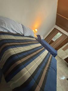 a bedroom with a bed with a blue and brown blanket at Lo de Celia in Chos Malal