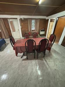 a dining room with a red table and chairs at Lo de Celia in Chos Malal