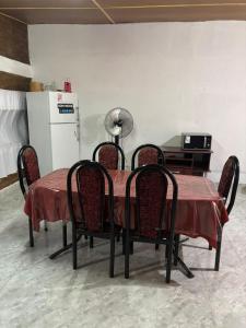 a dining room table with chairs and a refrigerator at Lo de Celia in Chos Malal