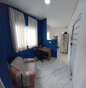 a living room with blue walls and a couch and a desk at Ap Interlagos apoia adversidade in São Paulo