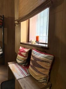 two pillows sitting on a bench next to a window at Cozy in Sarajevo