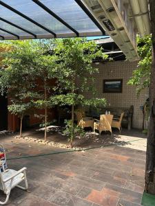an outdoor patio with tables and chairs and trees at D&B apartments in Lo de Marcos
