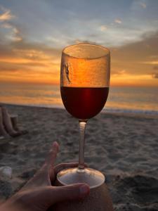 a person holding a glass of wine on the beach at D&B apartments in Lo de Marcos +4 photos