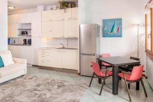 a kitchen with a table and chairs and a refrigerator at Front Lake Apartment Rainer in Bardolino