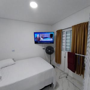 a bedroom with a bed and a flat screen tv at Ap Interlagos apoia adversidade in São Paulo