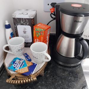 a counter with two cups and a coffee maker at Ap Interlagos apoia adversidade in São Paulo