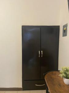 a black refrigerator in a kitchen with a table at Tlaxcala Apartment # 5 in Ciudad Obregón