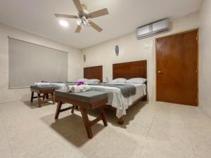 a bedroom with two beds and a ceiling fan at Casa Bugambilia Progreso #3 in Progreso