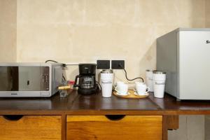 a counter with a microwave and coffee cups on it at Casa Bugambilia Progreso #3 in Progreso