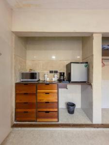 a small kitchen with a microwave and a refrigerator at Casa Bugambilia Progreso #3 in Progreso
