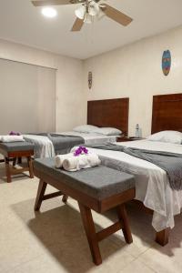 a room with three beds with towels on a bench at Casa Bugambilia Progreso #3 in Progreso