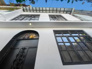 a white house with a black door and windows at Casa Magdalena N2 in San Pedro La Laguna