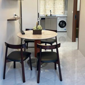 a dining room table with four chairs and a kitchen at Nadi Easy Home Near McDonalds in Nadi
