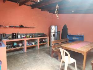 a kitchen with a table and a refrigerator at Passiflora Backpackers Samara in Sámara