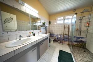 a large bathroom with two sinks and a shower at Studio bord de mer Home Dominik in Le Robert +14 photos